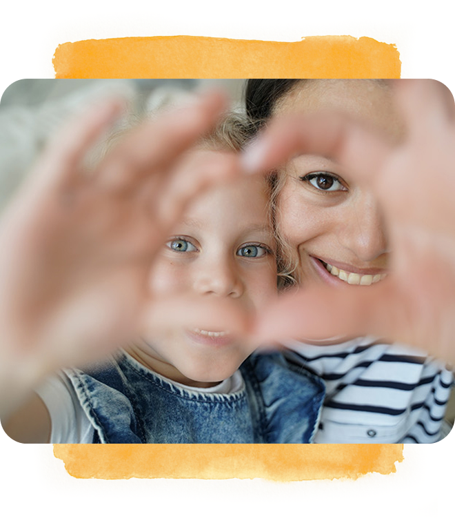 Smiling woman and child making a heart shape with their hands